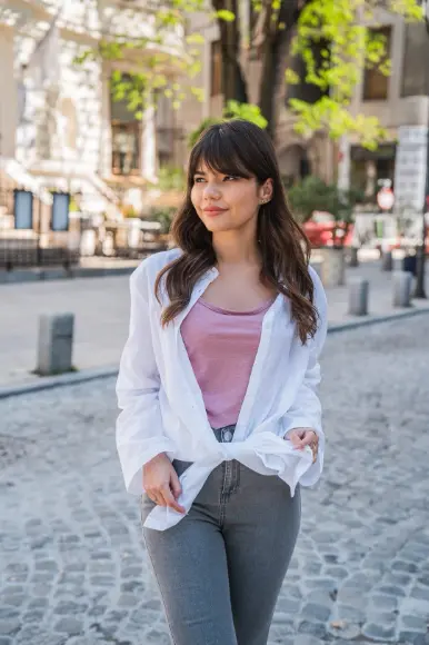 Frau mit rosane Shirt und weißer Bluse, sowie grauer Jeans von Ergee